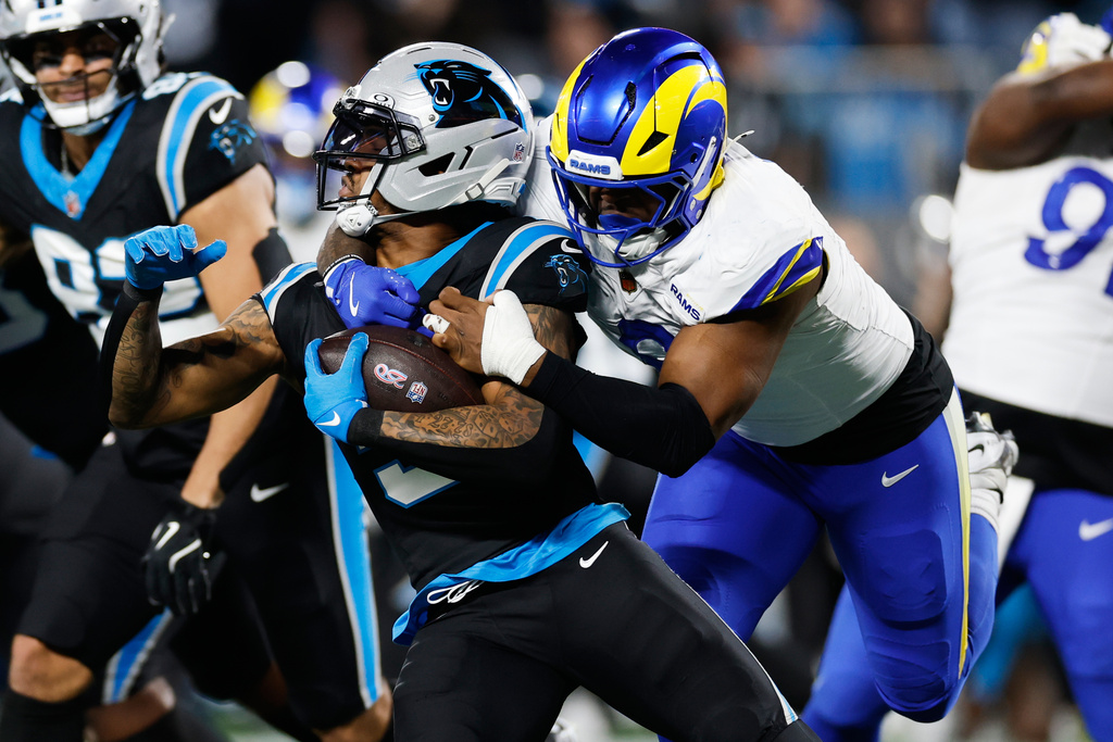 Carolina Panthers running back Rico Dowdle (5) is tackled by Los Angeles Rams linebacker Jared Verse during the first half of an NFL wild-card playoff football game, Saturday, Jan. 10, 2026, in Charlotte, N.C. (AP Photo/Rusty Jones)