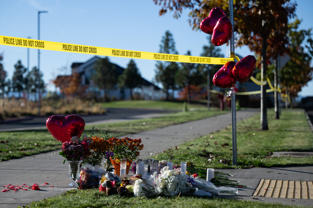 Flowers and candles are seen at a makeshift memorial outside Silver Rail Elementary in Bend, Ore., Friday, Oct. 16, 2026, a day after a deadly shooting. (AP Photo/Joe Kline)