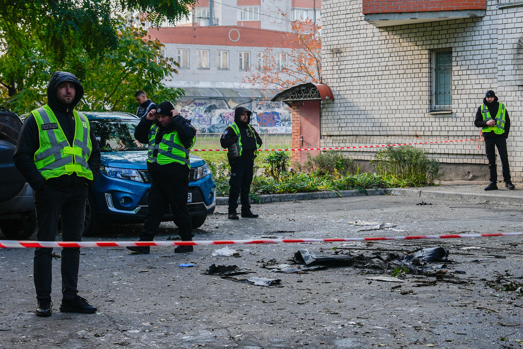 Police standby as debris lies on the ground outside an apartment building that Russian attacks damaged, Wednesday, Oct. 22, 2025, in Kyiv, Ukraine. (AP Photo/Julia Demaree Nikhinson)