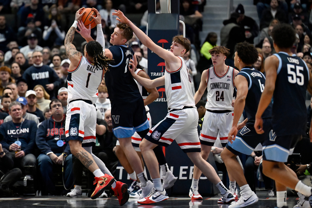 UConn guard Solo Ball (1) grabs a rebound against Villanova forward Duke Brennan (24) in the first half of an NCAA college basketball game, Saturday, Jan. 24, 2026, in Hartford, Conn. (AP Photo/Jessica Hill)
