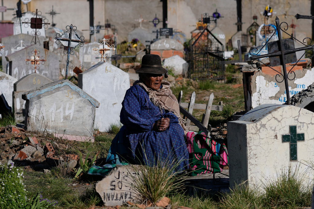 A woman sits by the grave of a relative during Day of the Dead festivites at the Tarapaca cemetery in El Alto, Bolivia, Sunday, Nov. 2, 2025. (AP Photo/Juan Karita)