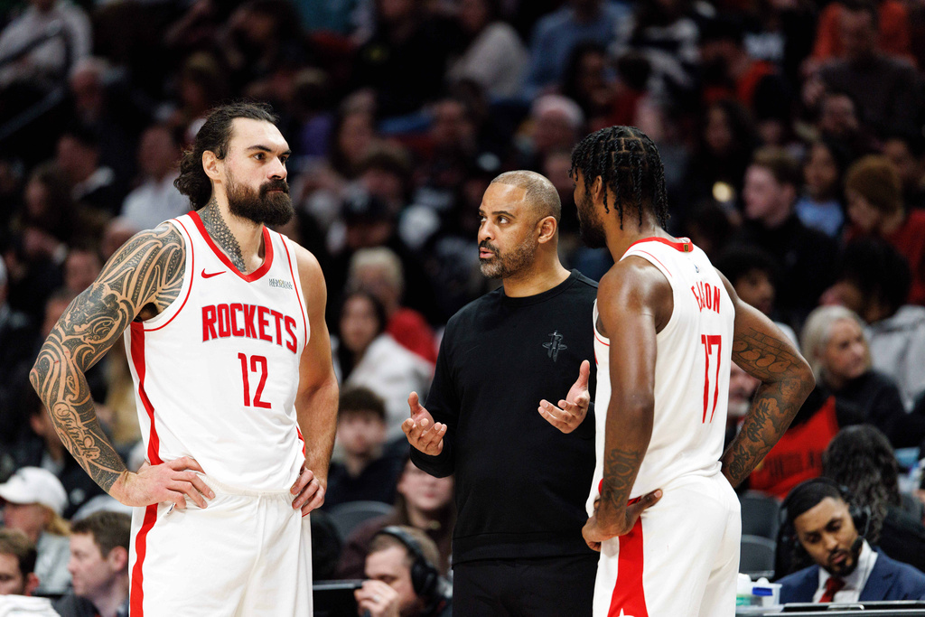 Houston Rockets head coach Ime Udoka, center, speaks with Houston Rockets center Steven Adams left, and forward Tari Eason, right, during the second half of an NBA basketball game against the Portland Trail Blazers, Friday, Jan. 9, 2026, in Portland, Ore. (AP Photo/Howard Lao)