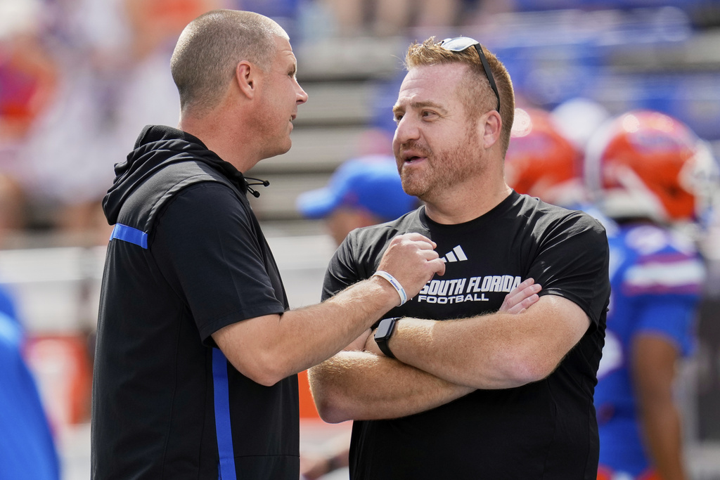 Florida head coach Billy Napier, left, and South Florida head coach Alex Golesh greet each other before an NCAA college football game, Saturday, Sept. 6, 2025, in Gainesville, Fla. (AP Photo/John Raoux)