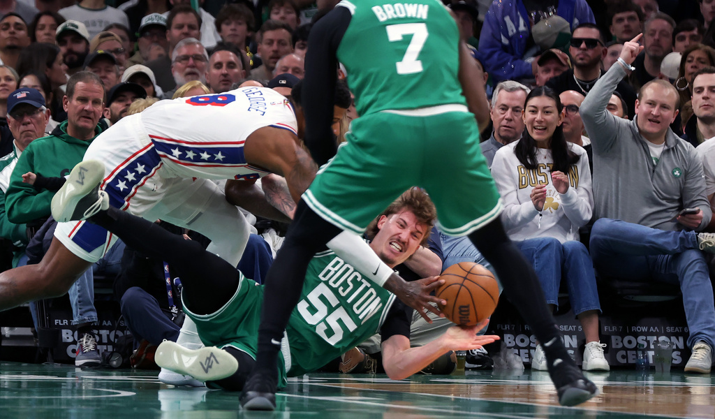 Boston Celtics' Baylor Scheierman gets off a pass as he battles with the Philadelphia 76ers' Paul George during the first half of Game 7 in a first-round NBA basketball playoffs series, Saturday, May 2, 2026 in Boston. (AP Photo/Jim Davis)