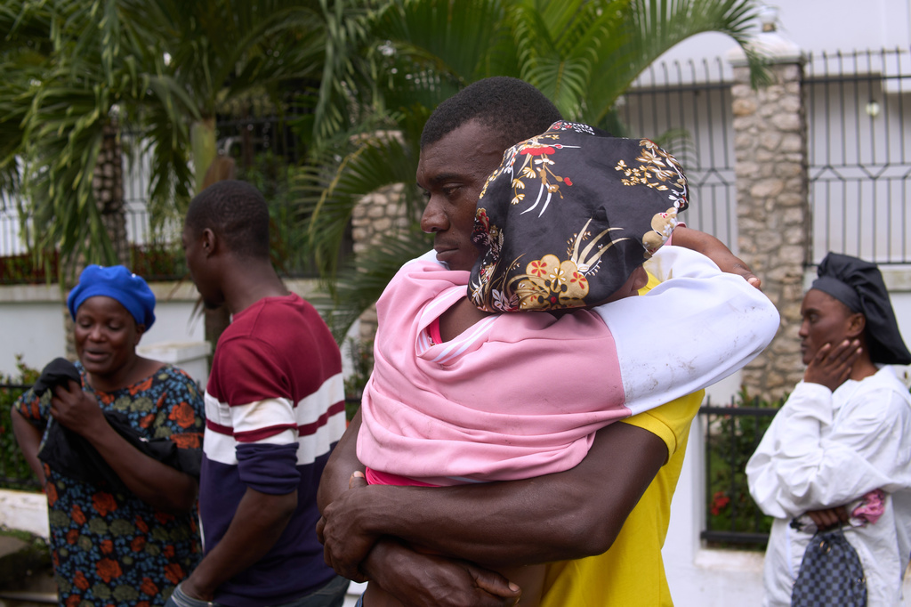 Relatives of a victim of a deadly stampede embrace each other in Milot, Haiti, Sunday, April 12, 2026. (AP Photo/Ketlain Difficile)