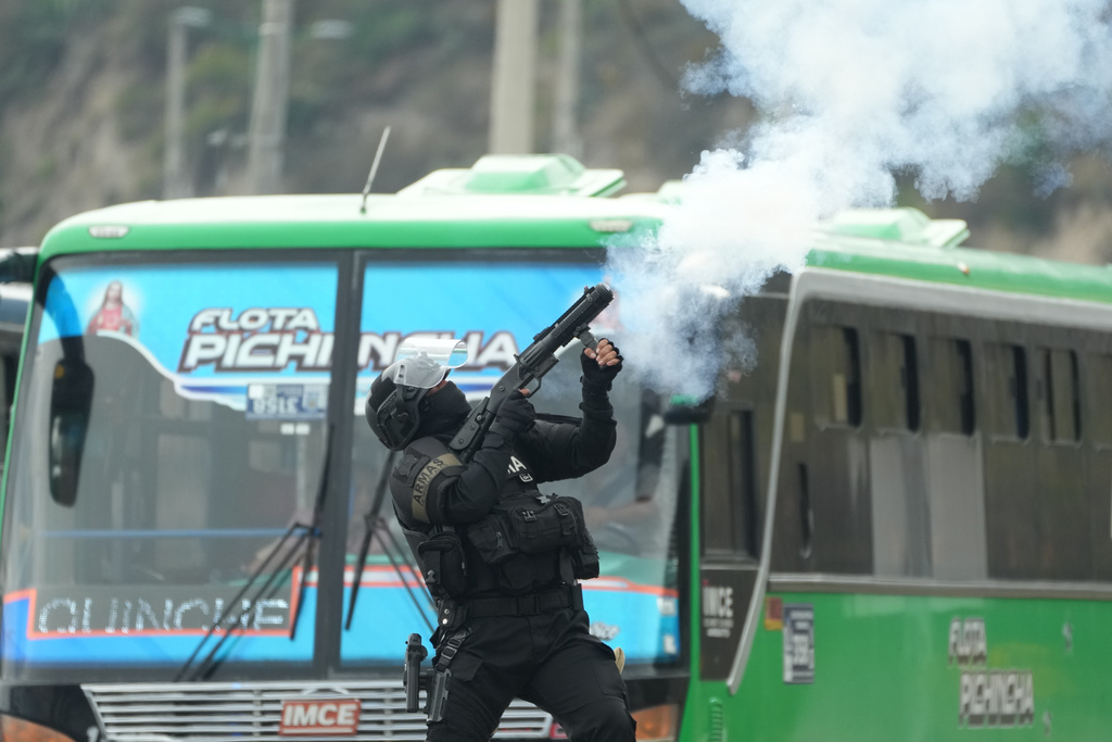 A police officer launches tear gas during protests over the elimination of the diesel subsidy by President Daniel Noboa's government, in Calderon, Ecuador, Thursday, Oct. 9, 2025. (AP Photo/Dolores Ochoa)