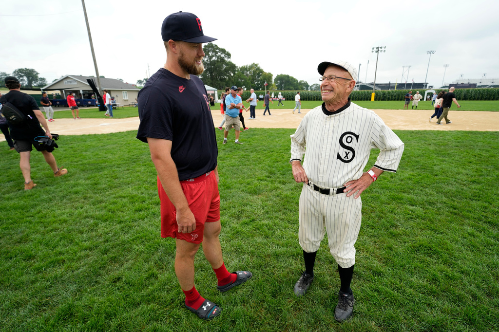 Philadelphia Phillies pitcher Jonathan Bowlan talks with Paul Scherrman, right, of Farley, Iowa, before a baseball game against the Minnesota Twins at the Field of Dreams movie site, Thursday, Aug. 13, 2026, in Dyersville, Iowa. (AP Photo/Charlie Neibergall)