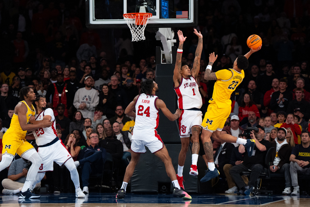 Michigan's Yaxel Lendeborg (23) guarded by St. John forward Dillon Mitchell (1), shoots a two-pointer during the second half of an NCAA college basketball exhibition game, Saturday, Oct. 25, 2025, in New York. (AP Photo/Angelina Katsanis)