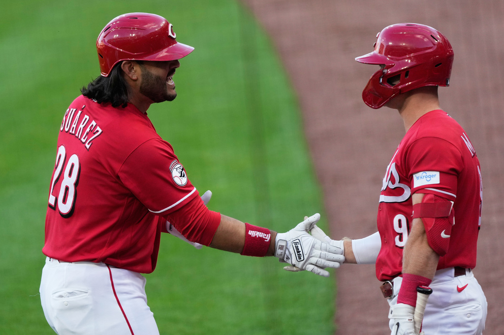 Cincinnati Reds' Eugenio Suárez, left, celebrates with Matt McLain, right, after hitting a two-run homer during the first inning of a baseball game against the New York Mets in Cincinnati, Monday, June 15, 2026. (AP Photo/Carolyn Kaster)