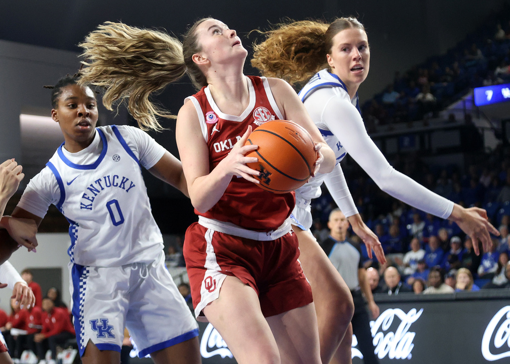 Oklahoma's Payton Verhulst, center, shoots between Kentucky's Jordan Obi (0) and Amelia Hassett, right, during the first quarter of an NCAA college basketball game in Lexington, Ky., Sunday, Jan. 11, 2026. (AP Photo/James Crisp)