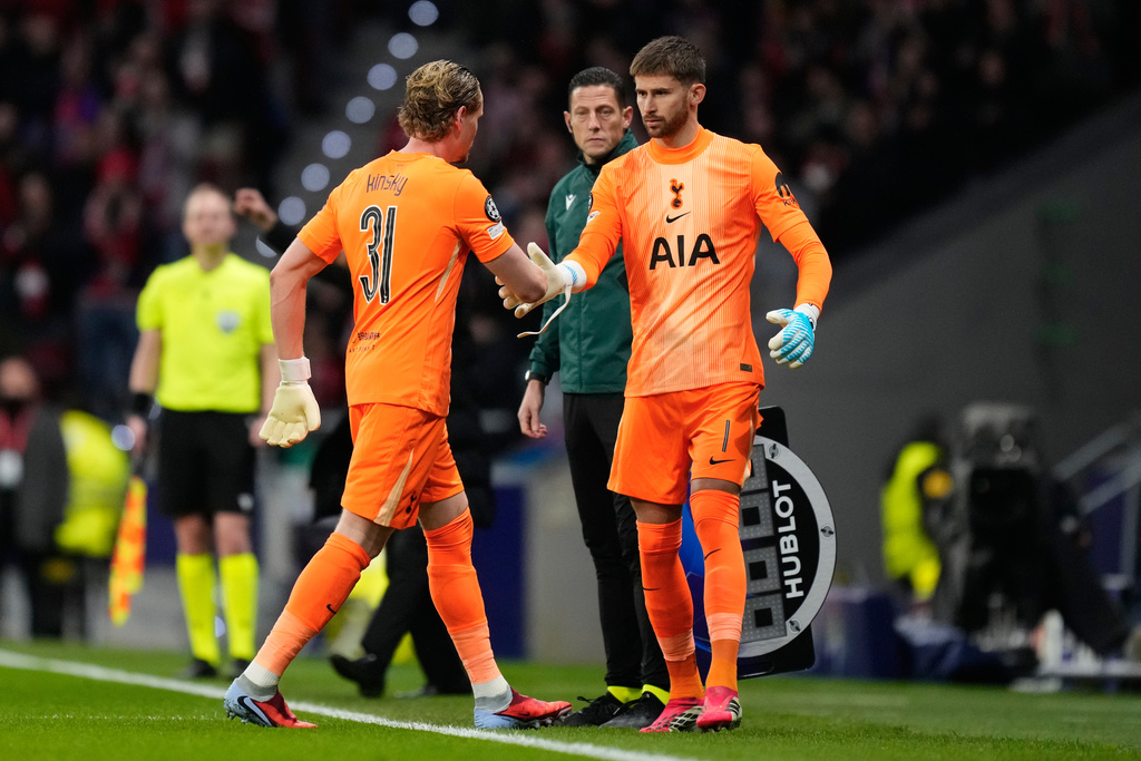 Tottenham's goalkeeper Antonin Kinsky, left, shakes hands with Tottenham's goalkeeper Guglielmo Vicario after substitution during the first leg of the Champions League round of 16 soccer match between Atletico Madrid and Tottenham in Madrid, Spain, Tuesday, March 10, 2026. (AP Photo/Jose Breton)