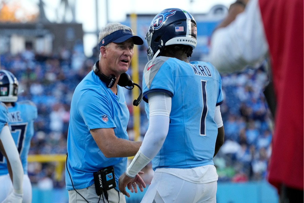 Tennessee Titans interim head coach Mike McCoy congratulates quarterback Cam Ward (1) after a touchdown against the Seattle Seahawks during the second half of an NFL football game Sunday, Nov. 23, 2025, in Nashville, Tenn. (AP Photo/George Walker IV)