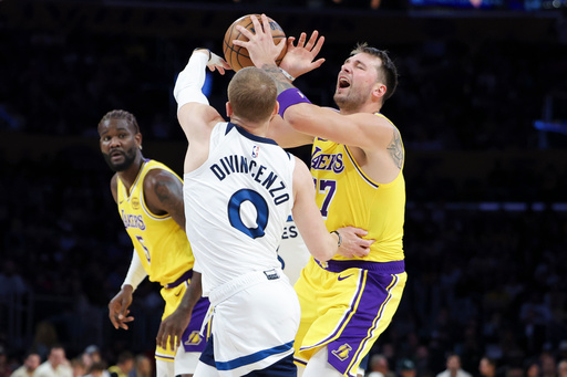 Los Angeles Lakers guard Luka Doncic, right, reacts while driving against Minnesota Timberwolves guard Donte DiVincenzo (0) as Lakers center Deandre Ayton, left, watches during the first half of an NBA basketball game, Friday, Oct. 24, 2025, in Los Angeles. (AP Photo/Jessie Alcheh) Los Angeles Lakers guard Luka Doncic, right, reacts while driving against Minnesota Timberwolves guard Donte DiVincenzo (0) as Lakers center Deandre Ayton, left, watches during the first half of an NBA basketball game, Friday, Oct. 24, 2025, in Los Angeles. (AP Photo/Jessie Alcheh)