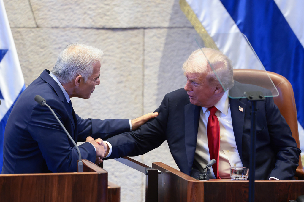 President Donald Trump shakes hands with Israeli opposition leader Yair Lapid at the Knesset, Israel's parliament, Monday, Oct. 13, 2025, in Jerusalem. (Evelyn Hockstein/Pool via AP)