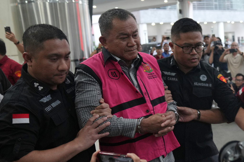 Former deputy head of Indonesia's National Nutrition Agency Lodewyk Pusung, center, is escorted by prosecutors to a waiting detention car after being named as a corruption suspect, at the Attorney Genera's Office in Jakarta, Indonesia, Wednesday, June 3, 2026. (AP Photo/Achmad Ibrahim)