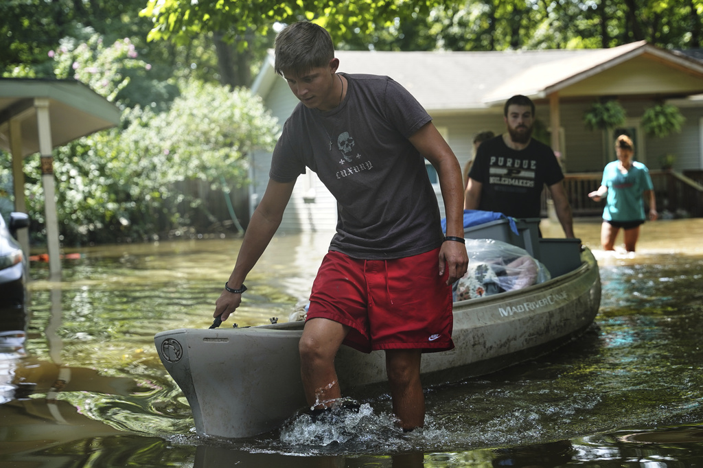 Residents transport items from their flooded homes by kayak in Indianapolis, Sunday, Aug. 16, 2026. (AP Photo/Obed Lamy)