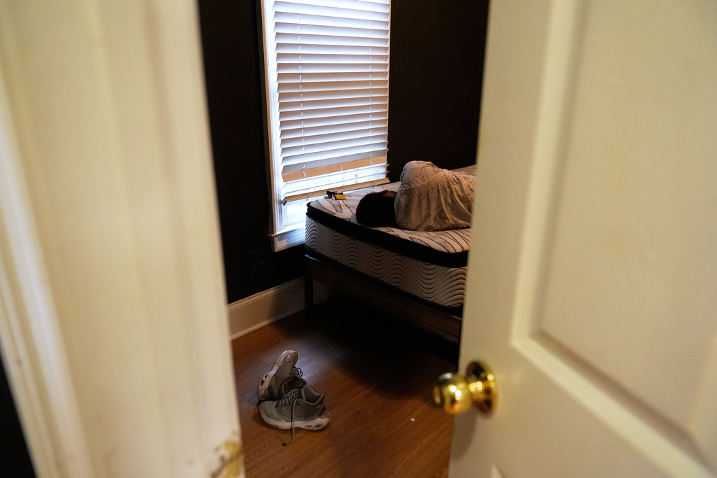Elias Washington rests on a bed left by a previous tenant in the new apartment in Atlanta on Aug. 1, 2025. (AP Photo/Brynn Anderson)