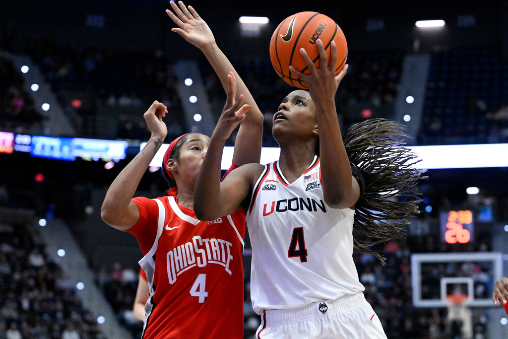 UConn guard Blanca Quinonez (4) shoots as Ohio State guard T'Yana Todd (4) defends in the first half of an NCAA college basketball game, Sunday, Nov. 16, 2025, in Hartford, Conn. (AP Photo/Jessica Hill)