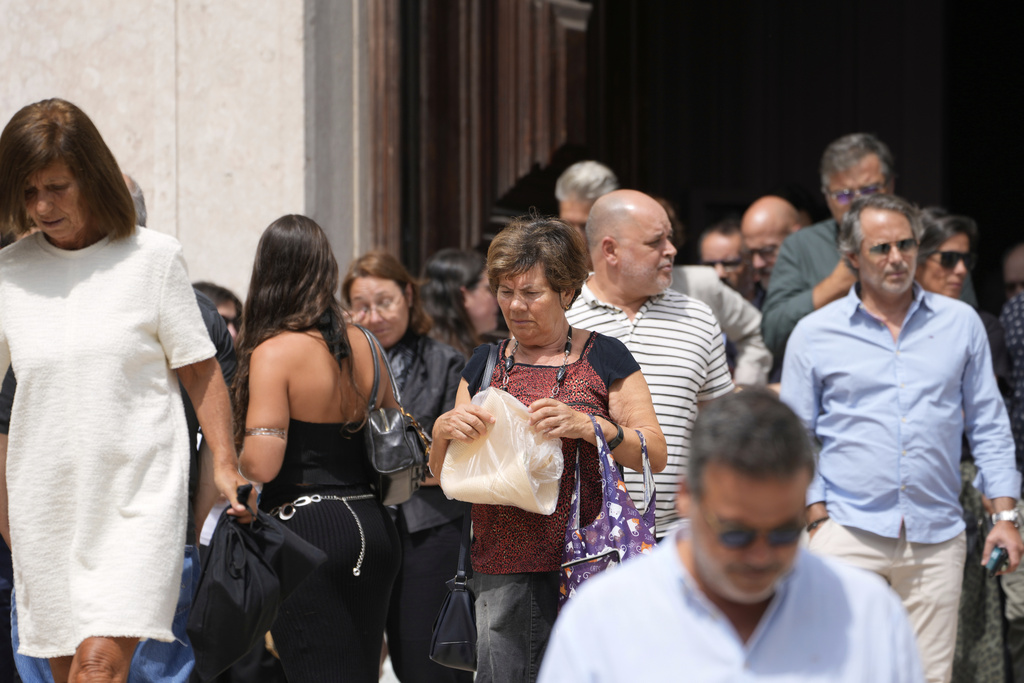Relatives, friends and colleagues leave a church service for the four coworkers of the charitable organization Santa Casa da Misericordia who perished in the derailment and crash of the Gloria funicular, at the Church of Saint Roch in Lisbon, Friday, Sept. 5, 2025. (AP Photo/Armando Franca)
