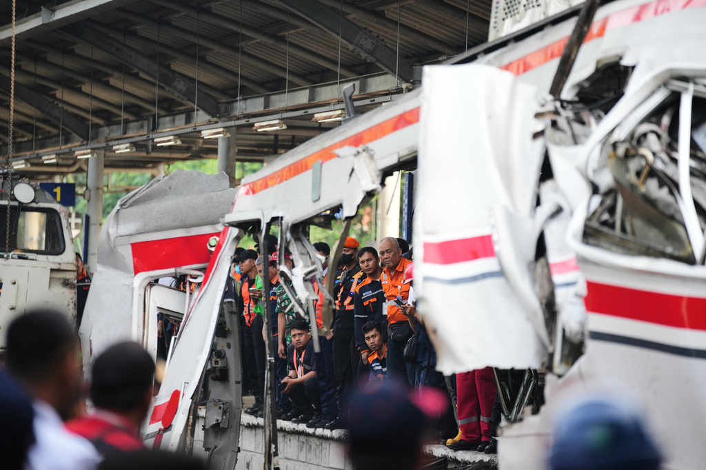 Workers and rescuers examine the wreckage following a train collision in Bekasi, Indonesia, Tuesday, April 28, 2026. (AP Photo/Tatan Syuflana)