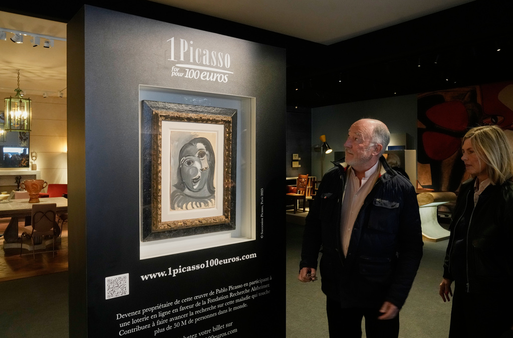 People look at the Head of a Woman by Pablo Picasso, painted in 1941, in Paris, Friday, April 10, 2026, where the draw will be handled by auction house Christie's next week. (AP Photo/Michel Euler)
