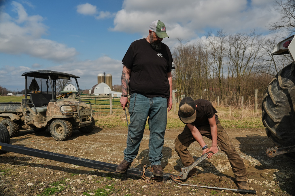Blake Greier, 13, works to repair a hitch as his father, Wayne, left, helps Tuesday, March 10, 2026, in Canfield, Ohio. (AP Photo/Joshua A. Bickel)
