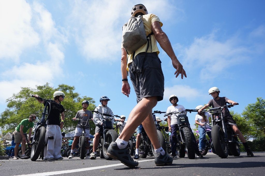 A group of riders listen to an instructor during an e-bike safety and training class Saturday, Aug. 8, 2026, in San Diego. (AP Photo/Gregory Bull)