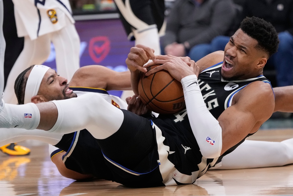 Milwaukee Bucks' Giannis Antetokounmpo, right, and Denver Nuggets' Zeke Nnaji battle for a loose ball during the second half of an NBA basketball game Friday, Jan. 23, 2026, in Milwaukee. (AP Photo/Morry Gash)