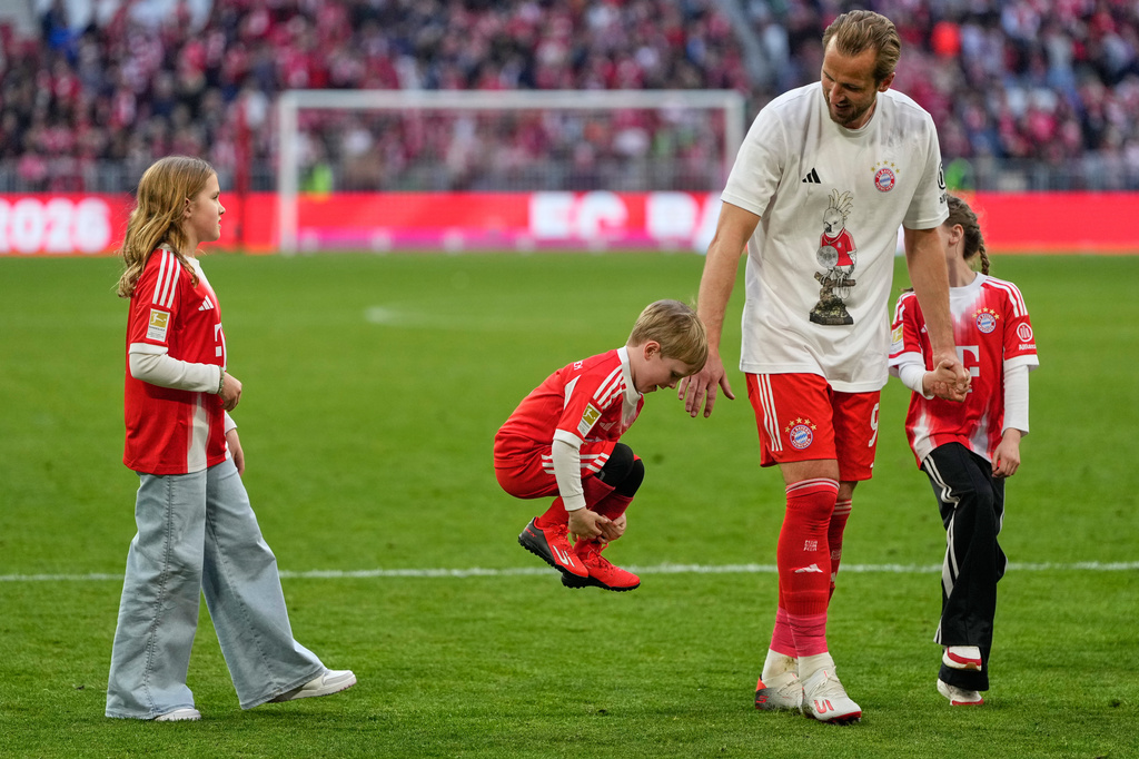 Bayern's Harry Kane walks with his children after his team clinched the German league title after a Bundesliga soccer match between Bayern and Stuttgart in Munich, Germany, Sunday, April 19, 2026. (AP Photo/Matthias Schrader)