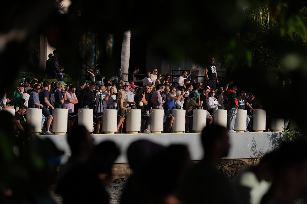 People gather along the Biscayne Bay waterfront to watch the controlled implosion of the former Mandarin Oriental Hotel on Brickell Key, Sunday, April 12, 2026, in Miami. (AP Photo/Rebecca Blackwell)