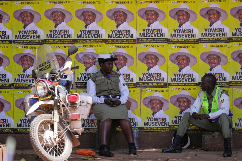 Traffic police officers sit in front of campaign posters of President Yoweri Museveni, the National Resistance Movement (NRM) presidential candidate, during the general election, in Kampala, Uganda, Thursday, Jan. 15, 2026. (AP Photo/Brian Inganga)