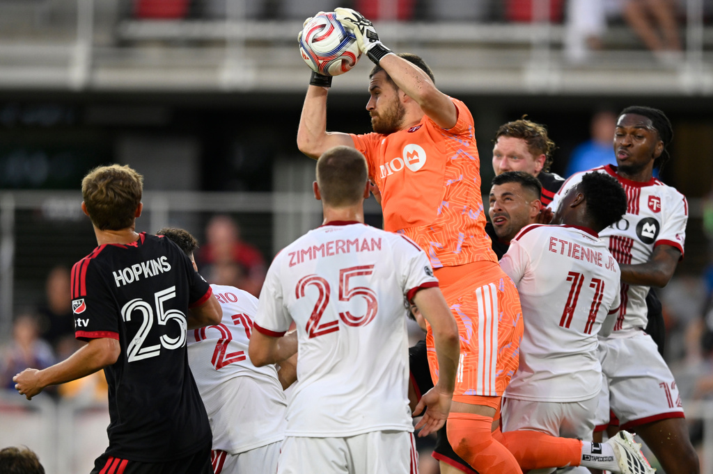 Toronto FC goalkeeper Luka Gavran, top, makes a save against a D.C. United cornerkick in the first half of an MLS soccer match, Saturday, July 25, 2026, in Washington. (AP Photo/John McDonnell)