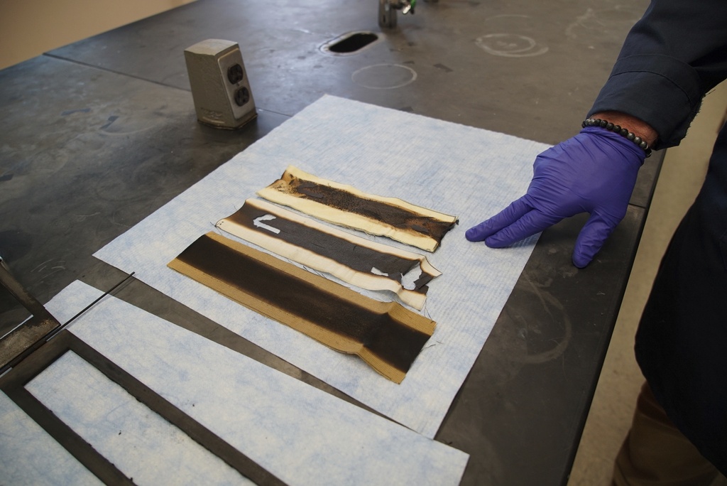 Charred pieces of non-PFAS-treated fabric sit on a lab bench following a burn test at North Carolina State University's Wilson College of Textiles in Raleigh, N.C., Aug. 8, 2025. (AP Photo/Allen G. Breed)