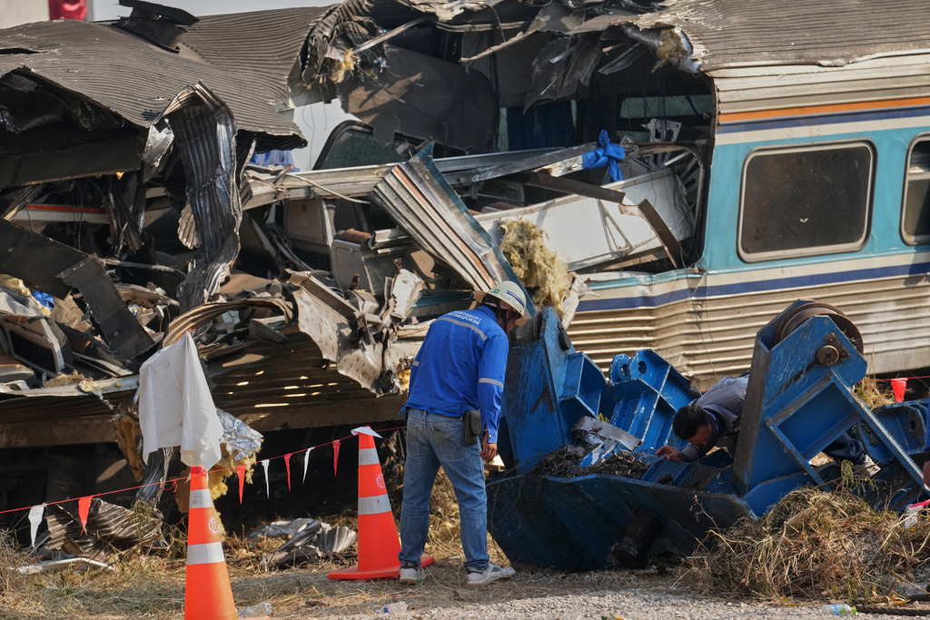 Train workers check the wreckage of train at the site where a construction crane fell into a passenger train on Wednesday, in Nakhon Ratchasima province, Thailand, Thursday, Jan. 15, 2026. (AP Photo/Sakchai Lalit)