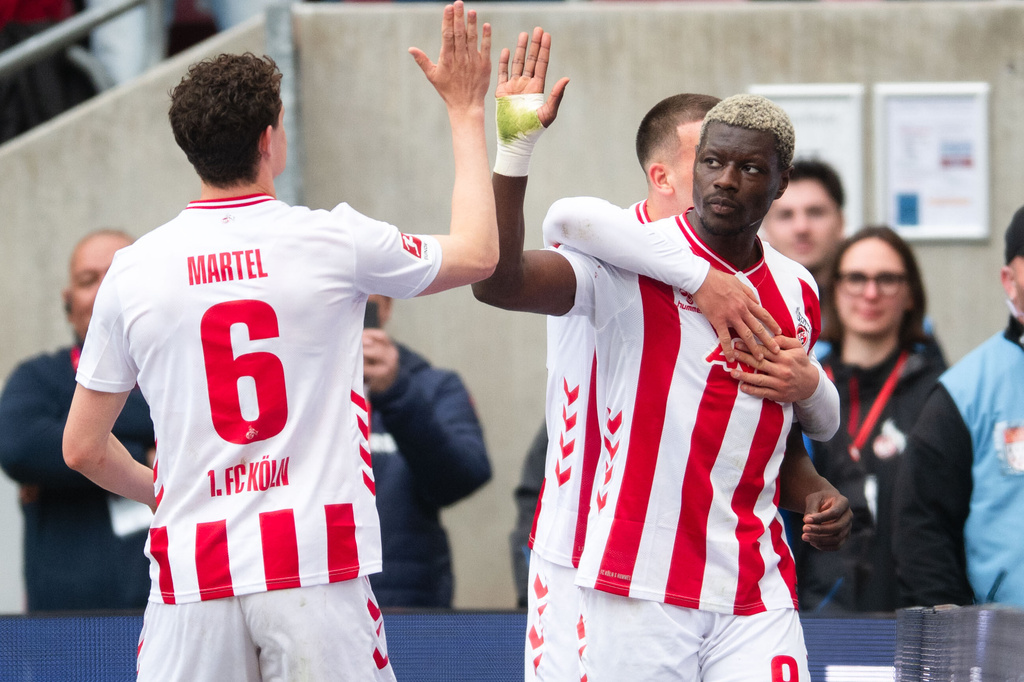 Koln's Ragnar Ache, right, celebrates with Eric Martel, left, after scoring his side's second goal during German Bundesliga soccer match between 1. FC Koln and Werder Bremen and Werder Bremen, in Cologne, Germany, Sunday, April 12, 2026. (Marius Becker/dpa via AP)