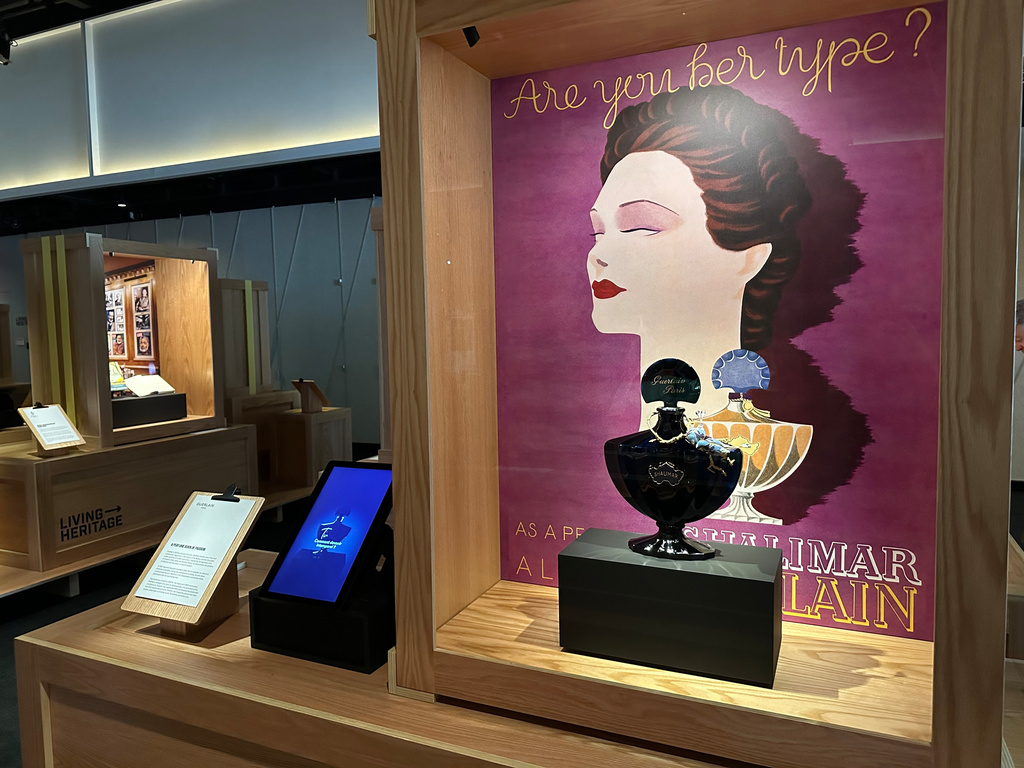 An advertisement from 1935 and a midnight-blue perfume bottle for Jacques Guerlain's Shalimar fragrance pictured on are display as part of the Comite Colbert "Hidden Treasures" exhibit at The Shed on Tuesday, May 26, 2026, in New York. (AP Photo/Beatrice Dupuy)