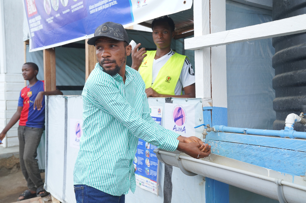 Wiza Bondele, a health worker on the prevention and control team, wash his hands upon arrival at the Ebola treatment centre in Ituri province, eastern Congo, Wednesday, Aug 5, 2026. (AP Photo/Dieudonne Dirole)