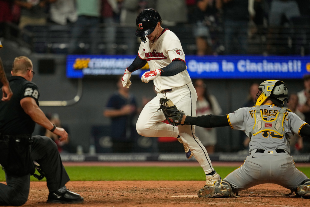Cleveland Guardians' Patrick Bailey, center, is tagged out by Pittsburgh Pirates catcher Rafael Flores Jr., right, at home plate in the ninth inning of the second baseball game of a split doubleheader in Cleveland, Saturday, June 18, 2026. (AP Photo/Sue Ogrocki)