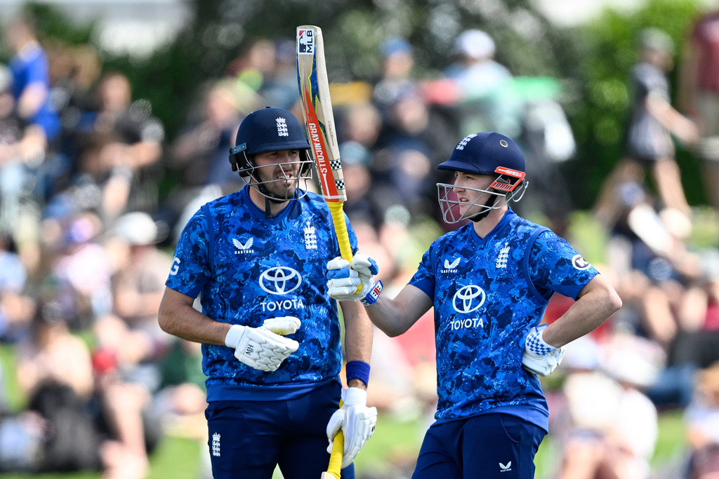 England captain Harry Brook, right, celebrates reaching 50 runs as teammate Jamie Overton looks on during the One Day international cricket match between New Zealand and England in Mt Maunganui, New Zealand, Sunday, Oct.26, 2025. (Andrew Cornaga/Photosport via AP)
