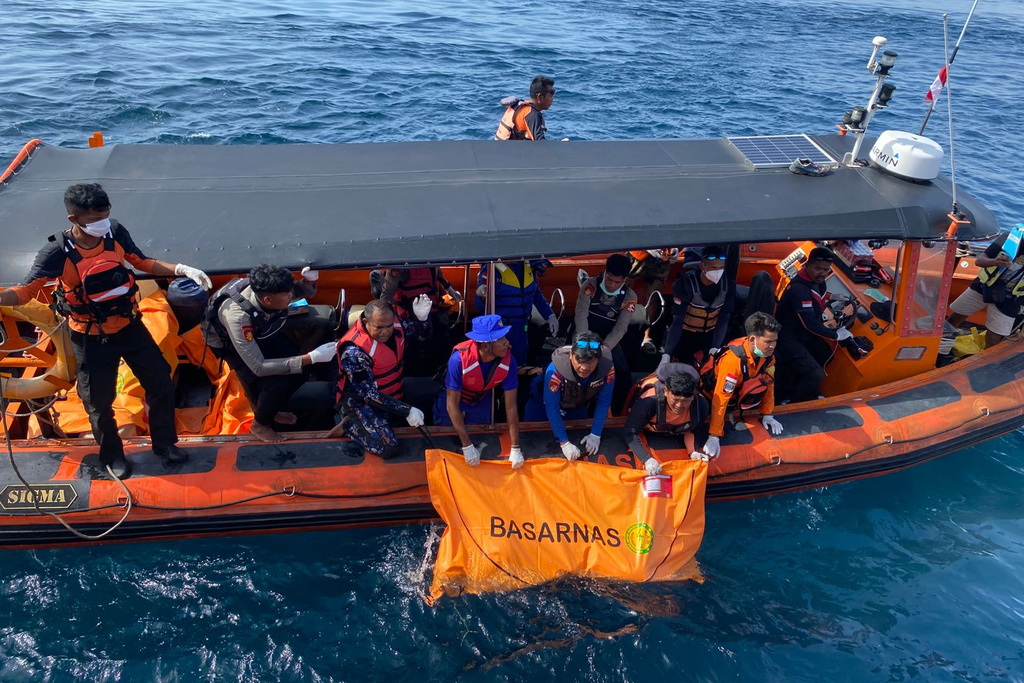 In this photo released by the Indonesian National Search and Rescue Agency (BASARNAS) on Sunday, Jan. 4, 2026, rescuers recover a body believed to be one of the victims of a tourist boat that sank on Dec. 26, in the waters near Padar Island in Komodo National Park, Indonesia. (BASARNAS via AP)