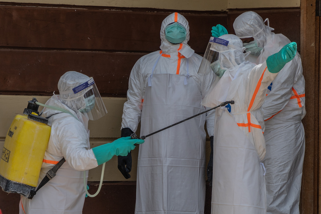 Health workers disinfect themselves after preparing the body of an Ebola victim at Citadelle Clinic in Bunia, Congo, Friday, June 12, 2026. (AP Photo/Moses Sawasawa)