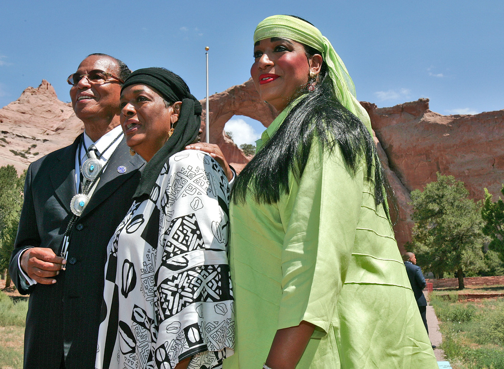 FILE - Nation of Islam leader Louis Farrakhan, his wife Khadijah Farrakhan, and their daughter, Maria Farrakhan Mohammad, pose for photographers in front of the Window Rock Navajo Monument, Wednesday, July 19, 2006, in Window Rock, Ariz. (AP Photo/Matt York, File)