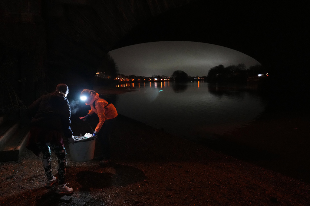 Participants in the Goodgym group collect litter from the riverbank to keep the River Thames free of plastic and other waste in London, Wednesday, Jan. 14, 2026. (AP Photo/Kirsty Wigglesworth)