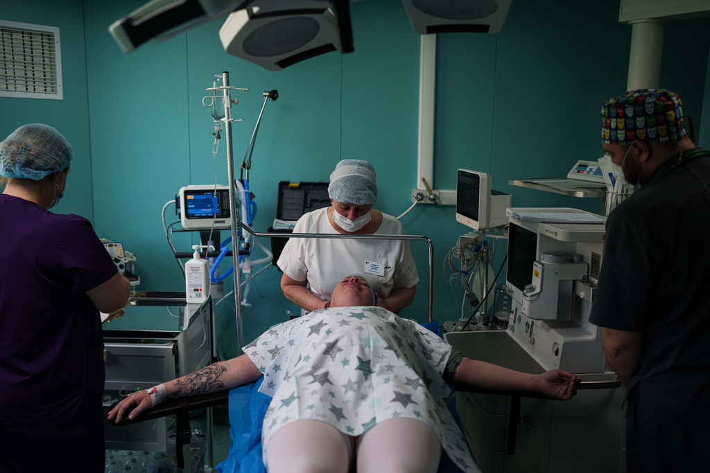 A medic calms Olha Karpenko before a cesarean section at the regional perinatal center of Zaporizhzhia, Ukraine, Wednesday, May 6, 2026. (AP Photo/Evgeniy Maloletka)