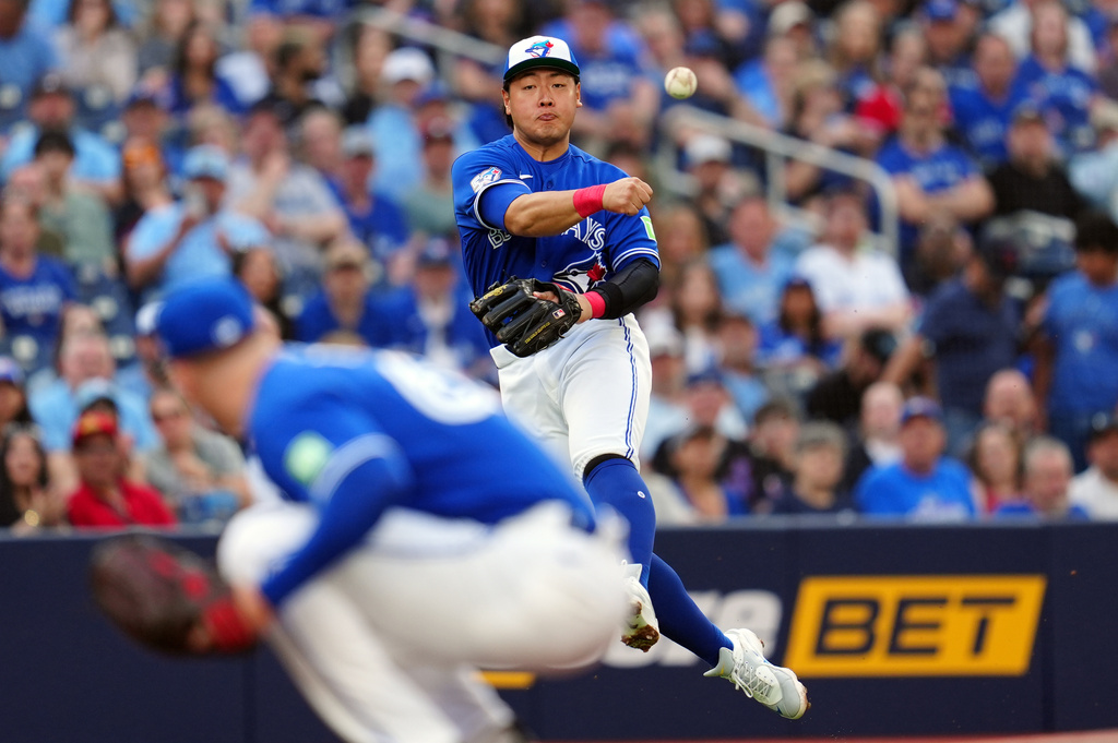 Toronto Blue Jays third baseman Kazuma Okamoto (7) makes a throw toward first base over Toronto Blue Jays pitcher Braydon Fisher (63) against the Miami Marlins during first inning of a baseball game in Toronto on Tuesday May 26, 2026. (Frank Gunn/The Canadian Press via AP)
