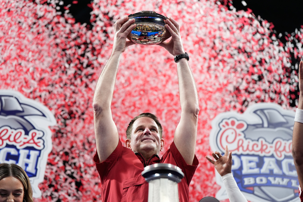 Indiana head coach Curt Cignetti holds up the trophy after the Peach Bowl NCAA college football playoff semifinal against Oregon, Friday, Jan. 9, 2026, in Atlanta. (AP Photo/Brynn Anderson)