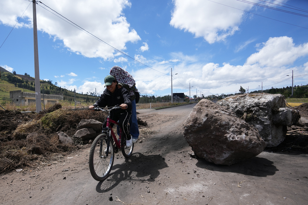 People traverse roadblocks placed by demonstrators protesting the elimination of the diesel subsidy by President Daniel Noboa's, government in Cayambe, Ecuador, Sunday, Oct. 5, 2025. (AP Photo/Dolores Ochoa)