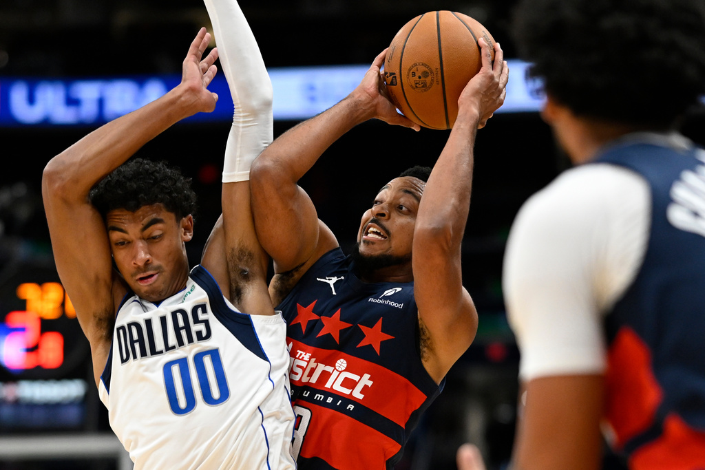 Dallas Mavericks guard Max Christie (00) fouls Washington Wizards guard CJ McCollum during the first half of an NBA basketball game Saturday, Nov. 8, 2025, in Washington. (AP Photo/John McDonnell)