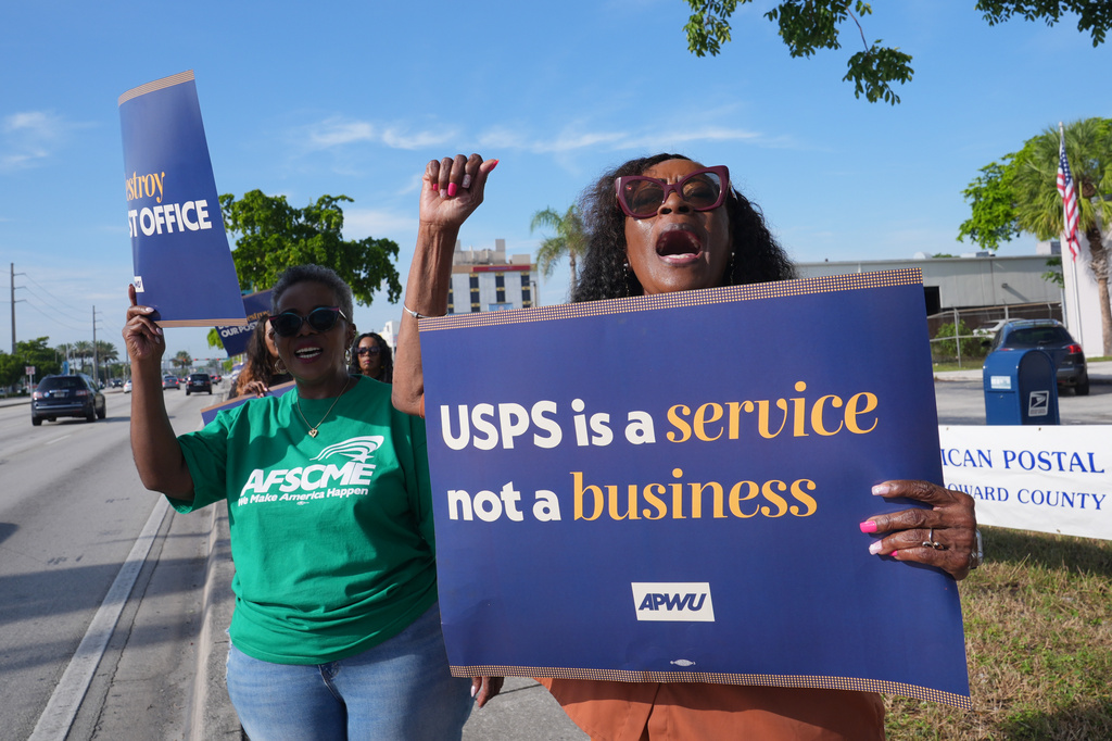 Joy L. Jackson, right, and Ketha Otis demonstrate against proposed changes to the U. S. Postal Service and President Donald Trump's executive order regarding a mail-in ballots Tuesday, July 28, 2026, in Miami Gardens, Fla.(AP Photo/Marta Lavandier)