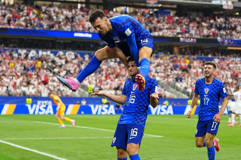 Croatia's Martin Baturina, bottom, is congratulated after scoring his side's first goal by Ivan Perisic after scored during the World Cup Group L soccer match between England and Croatia in Arlington, Texas, near Dallas, Wednesday, June 17, 2026. (AP Photo/Julio Cortez)